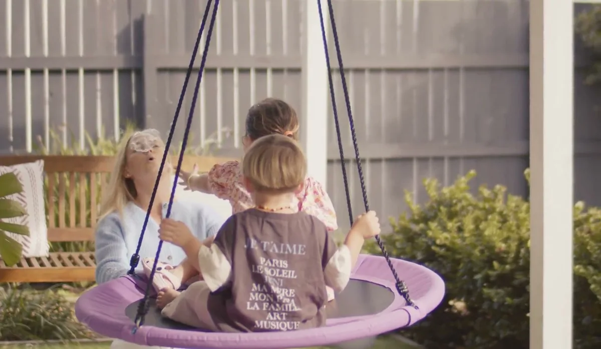 A child swinging on the outdoor nest swing at the practice